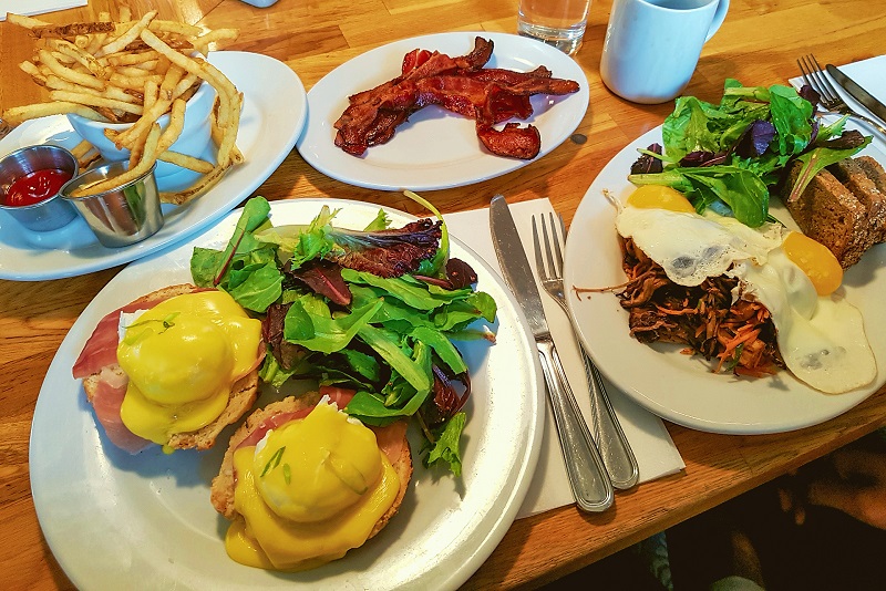 Brunch with eggs, bacon, salad and french fries